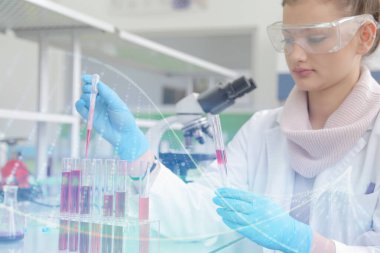 Laboratuvarda test tüpleriyle çalışan genç kadın laboratuvar bilim adamı.