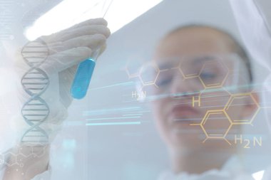 Laboratuvarda test tüpleriyle çalışan genç kadın laboratuvar bilim adamı.