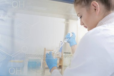 Laboratuvarda test tüpleriyle çalışan genç kadın laboratuvar bilim adamı.