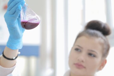 Laboratuvarda test tüpleriyle çalışan genç kadın laboratuvar bilim adamı.