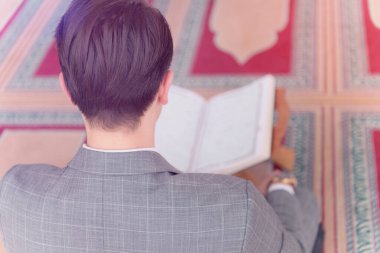 Dindar genç hafiz müslüman adam caminin içinde dua ediyor.