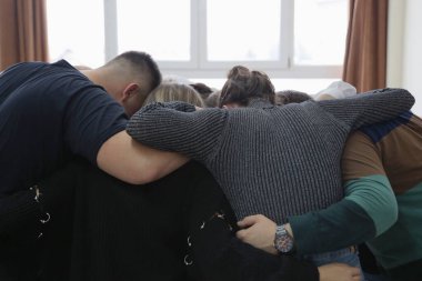 Teknik meslek eğitimindeki bir grup genç öğrenci, projeyi bitirmeyi ellerini birarada tutarak kutluyor.