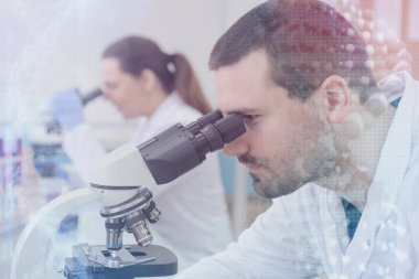 Laboratuvarda deney tüpleriyle çalışan iki genç bilim adamı...