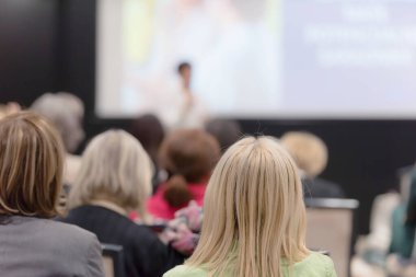 Elinde mikrofonla konuşan güzel bir iş kadını.