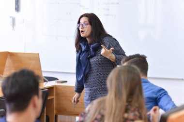 Bayan profesör öğrencilere açıkla ve onlarla iletişim kur.