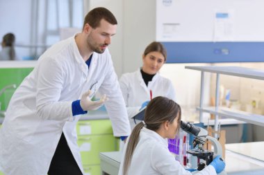 Laboratuvarda test tu ile çalışan bir grup genç bilim adamı.