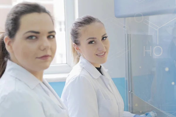 Twee jonge vrouwelijke laboratoriumwetenschappers werken in het lab met een test — Stockfoto