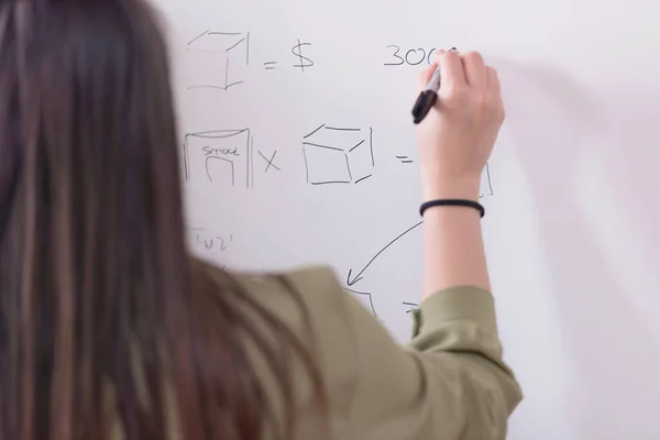 Young college female student writting on the chalkboard during a — Stock Photo, Image