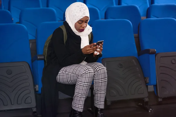 African american muslim  business womanusing phone after present