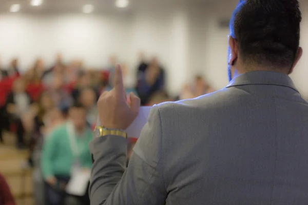 Giovane uomo d'affari in sala conferenze con pubblico dare — Foto Stock