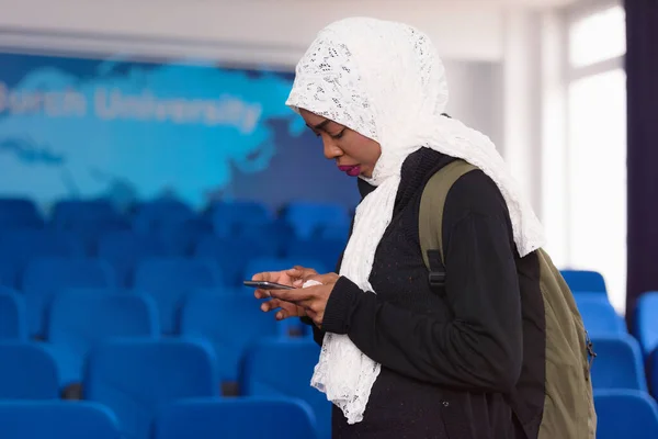 African american muslim  business womanusing phone after present