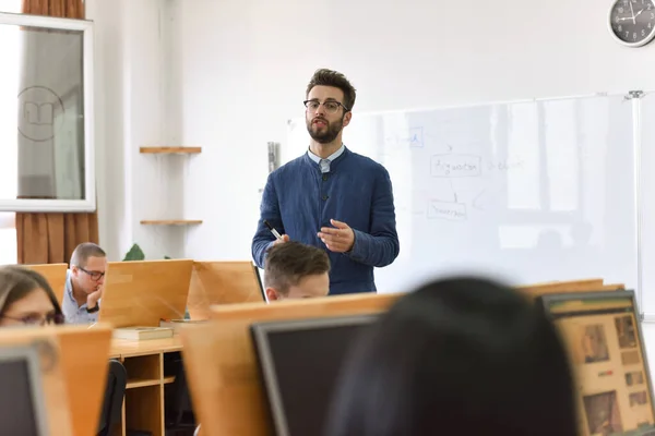 Profesor masculino explicar lección a los estudiantes e interactuar con ellos —  Fotos de Stock