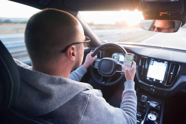 Uomo guida auto utilizzando il messaggio di sms del telefono cellulare o chiamando — Foto Stock