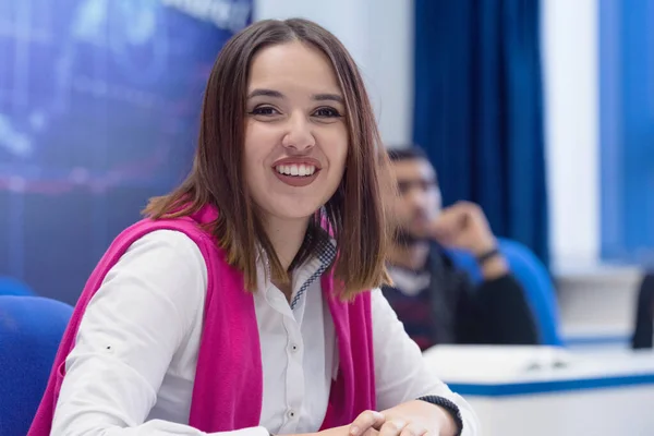 Universitaria estudiante en clase se sienta en su escritorio girando a s —  Fotos de Stock