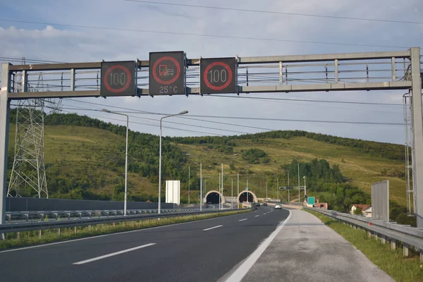 Panneaux routiers et autoroutiers avec vue sur le tunnel moderne nuageux — Photo
