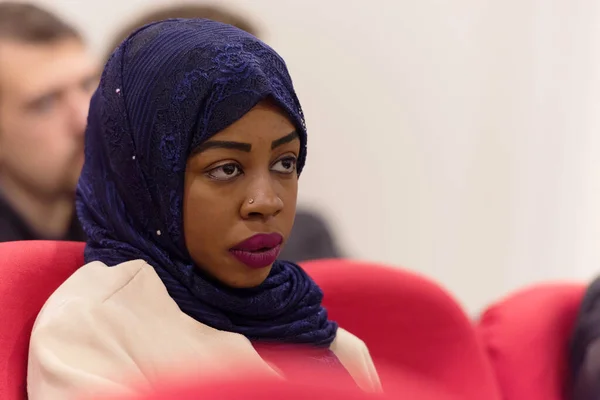 Schöne weibliche afrikanische muslimische Studentin mit Hijab hören Auto — Stockfoto
