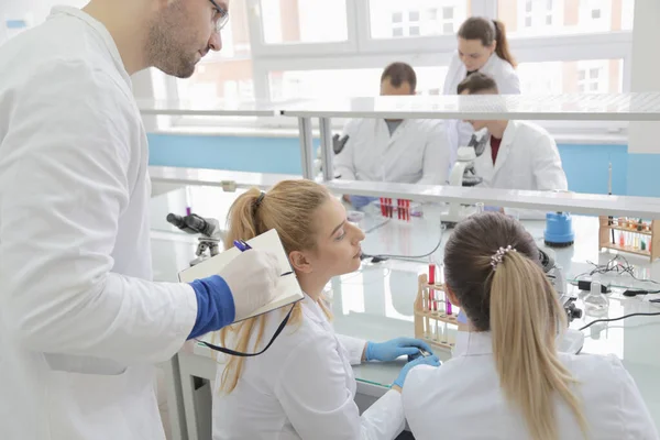 Gruppo di giovani scienziati di laboratorio che lavorano in laboratorio con test tu — Foto Stock