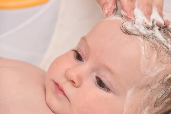 Hübsches drei Monate altes Mädchen, das von seiner Mutter zu Hause gebadet wird, europäisches Kind. — Stockfoto