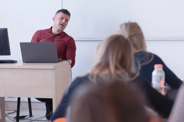 Man professor uit te leggen aan studenten en interactie met hen in de — Stockfoto