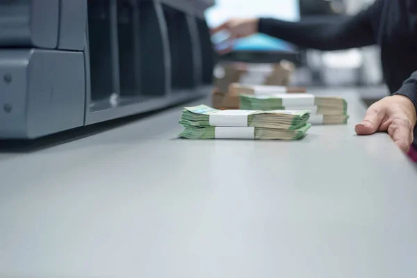 Bank employees sorting and counting money inside bank vault. Lar