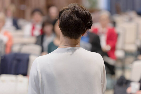 Beautiful business woman with microphone in her hand speaking at