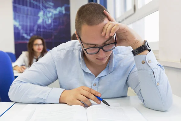 Youngmale student in math class overwhelmed by the math formula.