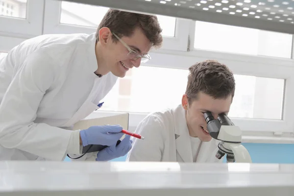 Dwóch młodych naukowców laboratoryjnych pracujących w laboratorium z probówkami — Zdjęcie stockowe