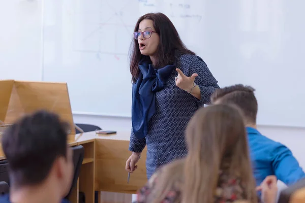 Vrouwelijke hoogleraar legt uit aan studenten en interacteert met hen in t — Stockfoto