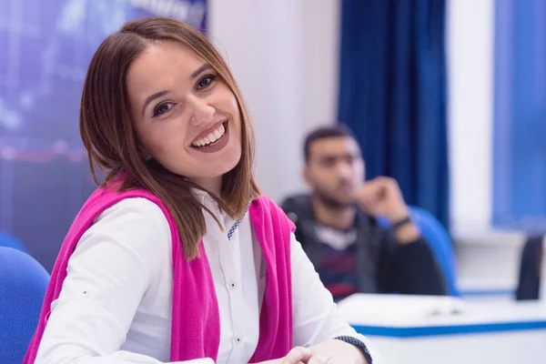 Étudiante universitaire en classe assise à son bureau se tournant vers s — Photo