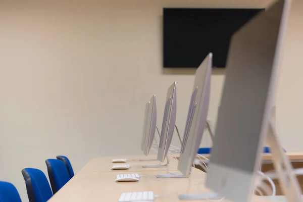 Escritório moderno com computadores em mesas. Sala de informática vazia em co — Fotografia de Stock