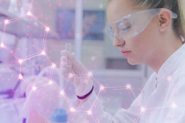 Laboratuvarda test tüpleriyle çalışan genç kadın laboratuvar bilim adamı.