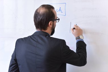 Erkek profesör öğrencilere ders veriyor ve onlarla iletişim kuruyor.