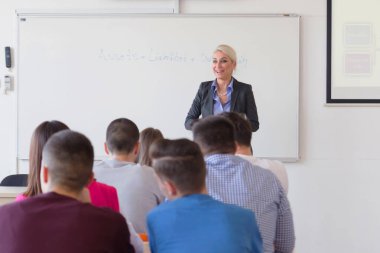 Çekici kadın profesör öğrencilere ve öğrencilere ders veriyor.