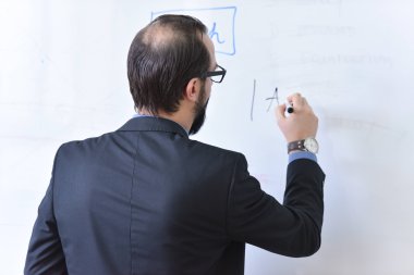 Erkek profesör öğrencilere ders veriyor ve onlarla iletişim kuruyor.