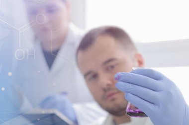 Laboratuvarda deney tüpleriyle çalışan iki genç bilim adamı...