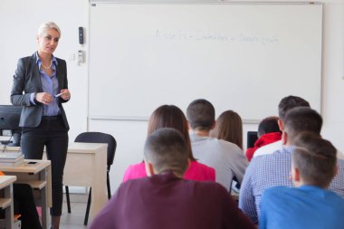 Çekici kadın profesör öğrencilere ve öğrencilere ders veriyor.