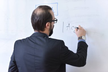 Erkek profesör öğrencilere ders veriyor ve onlarla iletişim kuruyor.