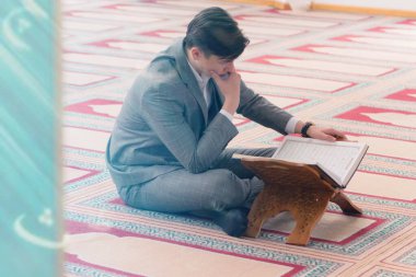 Dindar genç hafiz müslüman adam caminin içinde dua ediyor.