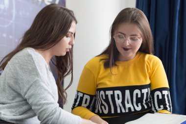 Campus life, students friendship.Two female students helping eac