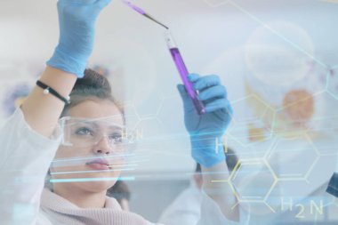 Laboratuvarda test tüpleri ve mikroskopla çalışan iki genç kadın ve erkek bilim adamı.,