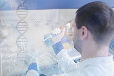 Laboratuvarda test tüpleriyle çalışan genç bir bilim adamı.