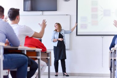 Bayan profesör öğrencilere dersi açıkla ve onunla iletişim kur.