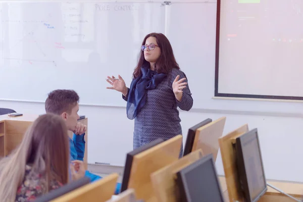 Női professzor elmagyarázza a diákoknak, és kölcsönhatásba lépnek velük t — Stock Fotó