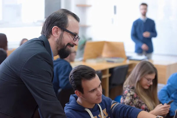 Skupina studentů studuje u profesora v moderním školním počítači — Stock fotografie