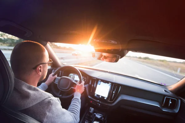 Un hombre conduciendo un coche. Éxito en movimiento. Un joven guapo conduciendo un auto. Un hombre sostiene el volante de un coche . — Foto de Stock