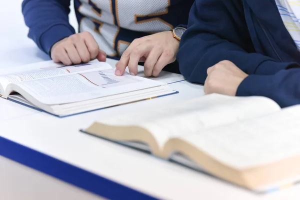 Uczelnia studencka w klasie siedzi przy biurku zwracając się do s — Zdjęcie stockowe