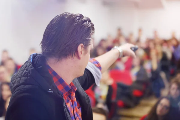 Giovane uomo d'affari in sala conferenze con pubblico dare — Foto Stock