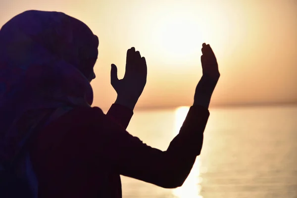 Mulher muçulmana orando no navio orando ao pôr do sol com as mãos para cima — Fotografia de Stock