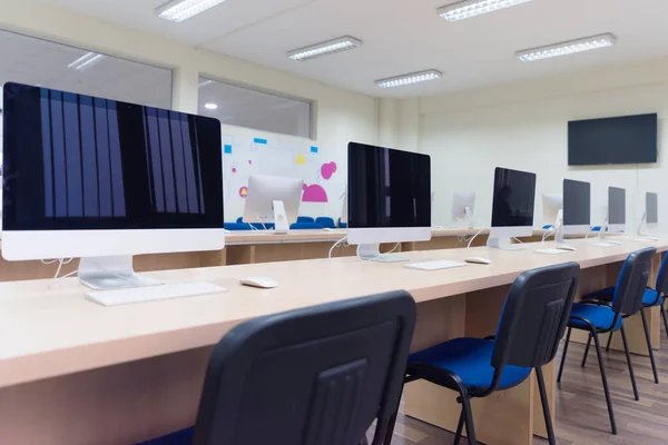 Escritório moderno com computadores em mesas. Sala de informática vazia em co — Fotografia de Stock