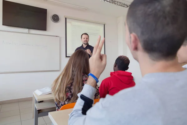 Profesor masculino explicar lección a los estudiantes e interactuar con ellos —  Fotos de Stock